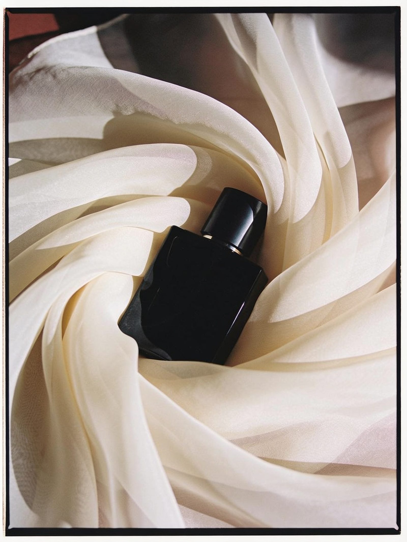 Black perfume bottle in cream tulle